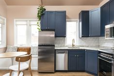 a kitchen with blue cabinets and stainless steel appliances