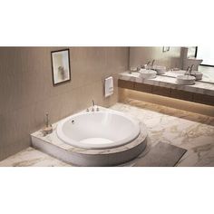 a large white bath tub sitting next to two sinks