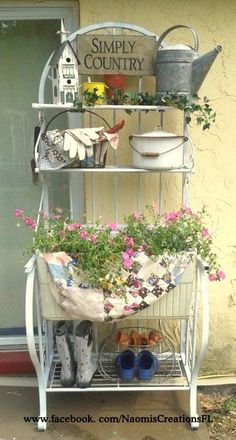 a potted plant stand with flowers and gardening equipment