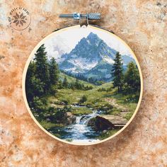 a painting is hanging on the wall in front of a stone surface with a mountain scene