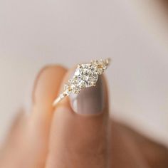 a woman's hand with a diamond ring on her finger, showing the side view