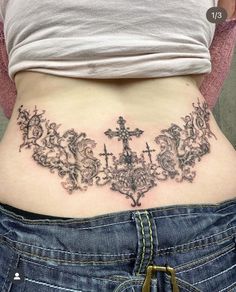 a woman with a cross tattoo on her lower back and the bottom part of her stomach