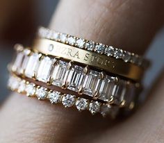 a close up of a person's hand with a gold ring and diamond band