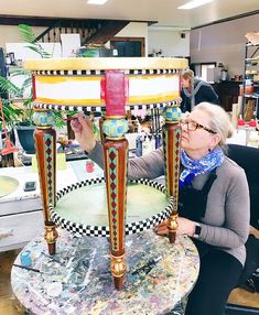 a woman sitting in front of a table that has been made to look like a lamp