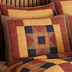 a quilted bed with red, yellow and blue pillows