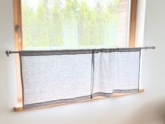 a window with two curtains hanging from it's side