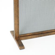 a close up of a metal screen on a wooden stand against a white background,