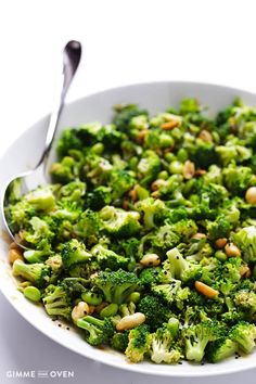 a white bowl filled with broccoli and nuts