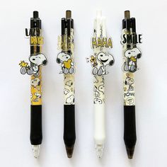 three pens with cartoon characters on them are lined up in a row, one is black and the other is white