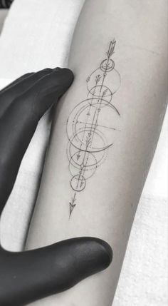 a woman's arm with an arrow tattoo on the left side of her body