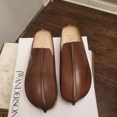 Brown Jw Anderson Clogs Size 39 Modern Slip-on Closed Toe Clogs, Slip-on Clogs With Rubber Sole And Plain Toe, Leather Sole Slip-on Clogs With Plain Toe, Slip-on Clogs With Leather Sole, Modern Brown Slip-on Clogs, Slip-on Clogs With Stitched Sole And Closed Toe, Modern Clogs With Leather Sole And Almond Toe, Modern Clogs With Branded Insole And Flat Heel, Modern Slip-on Clogs With Stitched Sole