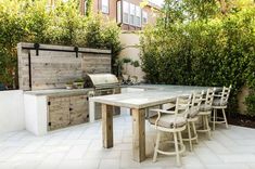 an outdoor kitchen and dining table with chairs