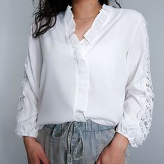 Gorgeous white v neck blouse with a ruffled collar and beautiful lace details on the sleeve. Ditch your boring white button up for this elevated blouse. Model wearing a Small. Runs true to size.