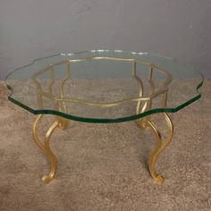 a glass and gold coffee table on carpeted floor