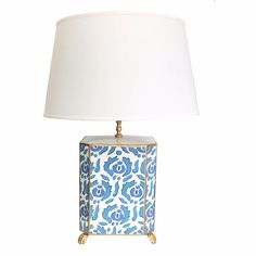 a blue and white table lamp with a white shade on the top, against a white background