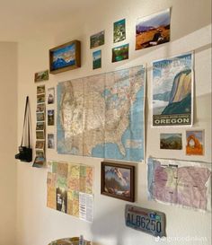 a wall filled with pictures and maps on it