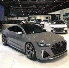 several cars are on display in a showroom at an automobile dealership, including the audi concept car