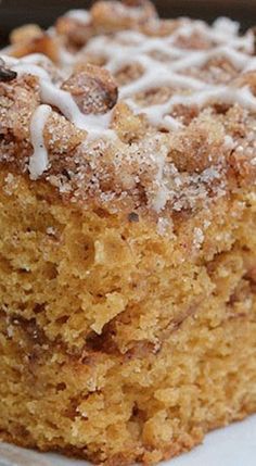 a close up of a piece of cake on a plate with icing and powdered sugar