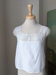 This Antique 1900s/10s white cotton + filet crochet camisole/corset cover would make a beautiful and breezy warm weather top! Drawstring at neckline, otherwise no closures.  Approximate Measurements of Garment laid flat: Bust: exactly 34"underarm to underarm, more like 34 1/2" below that  Waist: 36 1/2" Across bottom, it is 37" length: 17 1/2" from shoulder strap *Shown on 32"-25"-32" mannequin  XS Very good antique condition. Clean and intact overall, though there are a couple of hidden repairs Sleeveless Cotton Lace Top With Crochet Trim, Vintage Cotton Crochet Trim Top, Vintage Crochet Top With Lace Trim For Summer, Victorian Cotton Tops For Summer, Lace Top With Crochet Trim For Daywear, White Lace Top With Crochet Trim For Daywear, White Lace Top With Crochet Trim, Vintage Summer Crochet Top With Lace Work, Vintage Lace Top With Crochet Trim For Summer