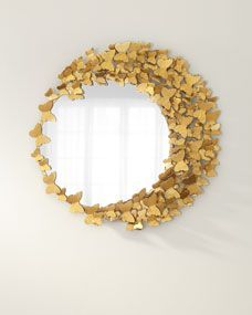 a mirror that is on the wall with some gold hearts around it and a white background