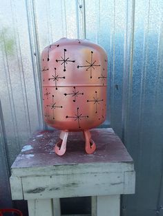 a pink vase sitting on top of a wooden table