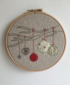 a close up of a embroidery on a wall hanging with buttons and ornaments in it