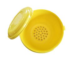 a yellow plastic strainer with a lid on the side and a hole in the middle