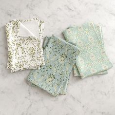 four napkins sitting on top of a marble counter