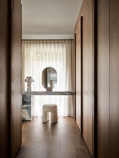 a room with wooden walls and a mirror on the wall, along with a stool