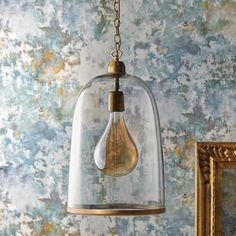 a light bulb hanging from a chain in front of a wall with blue and gold paint