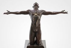 a bronze statue of a man with his arms spread out and lightning coming from behind him