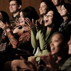 many people are sitting in the audience clapping and smiling for something to be heard by them