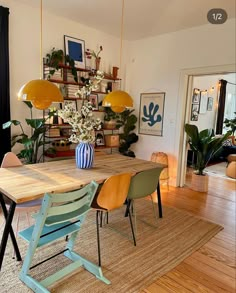 a dining room table with chairs and a vase filled with flowers on top of it