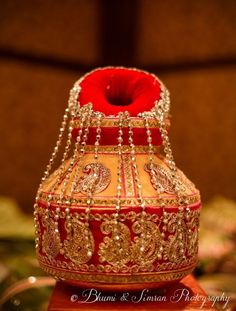 a red and gold vase sitting on top of a table