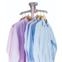 three shirts hanging on a clothes rack with a pink and blue hanger next to them