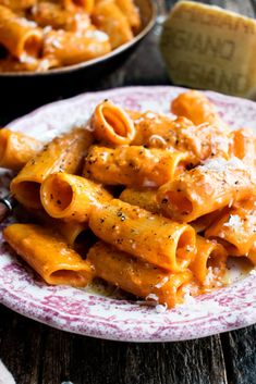 a plate full of pasta with sauce and parmesan cheese on the side,