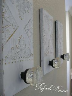 two white wall hangings with glass knobs on them