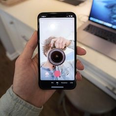 someone holding up their cell phone to take a selfie with the camera in front of them