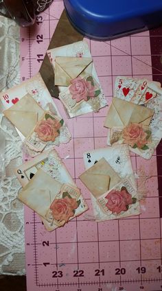 some old envelopes are sitting on a table with lace and pink flowers in them