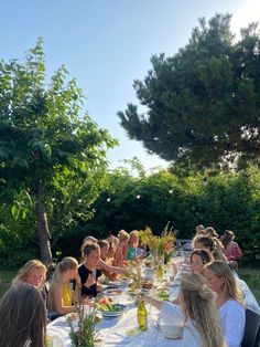 a group of people sitting at a long table