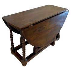 an old wooden desk with turned legs and a drawer on the top, sitting upright