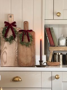 a kitchen with white cabinets and wooden cutting boards on top of the counter, decorated for christmas