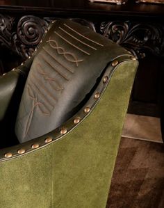 a green leather chair with studded arms