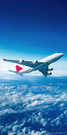 an airplane flying in the sky above clouds and blue sky with white fluffy clouds below