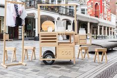 several wooden chairs and stools on the street