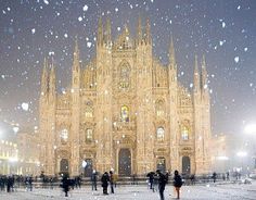 a painting of a cathedral with snow falling on the ground and people standing in front