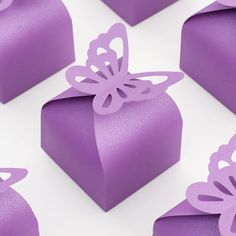 several purple boxes with cut out butterfly shapes on the top, and one in the middle