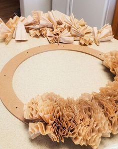 a round wooden frame with ruffles on top of it sitting on a table