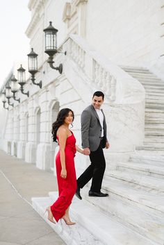 a man and woman in formal wear walking up the steps of an old building together