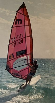 a person on a surfboard in the water with a sail attached to their body